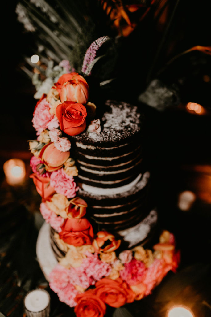 wedding cake with pink and red flowers and chocolate | Jungle-Disco Tulum Wedding by Feather and North photography